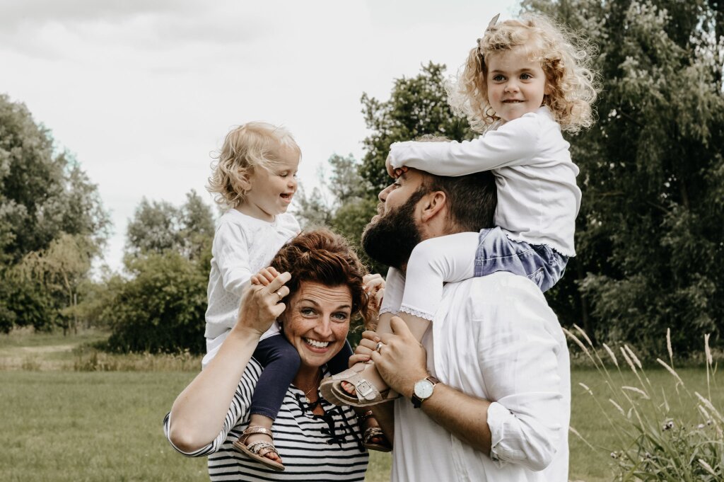 Gezinsfotografie in Tijnje — kinderen rennen door een weiland