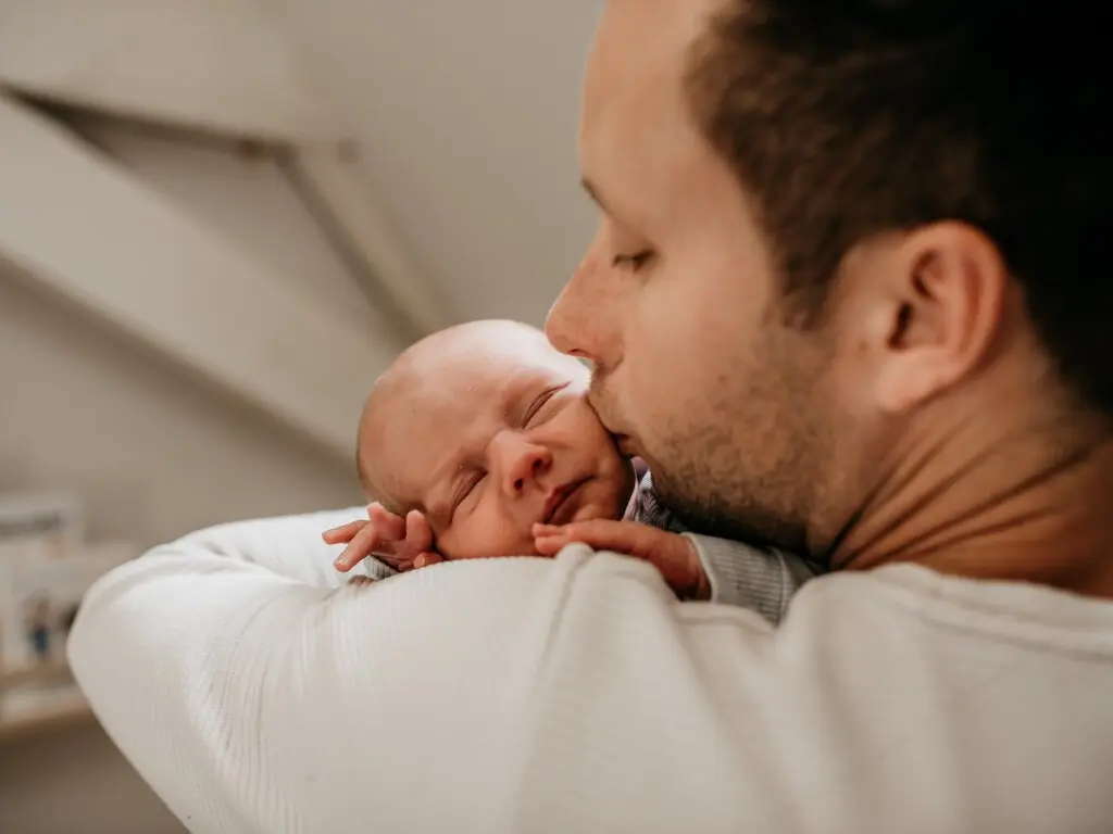 Warme gezinsmoment buiten — ouders en kind in zacht natuurlijk licht