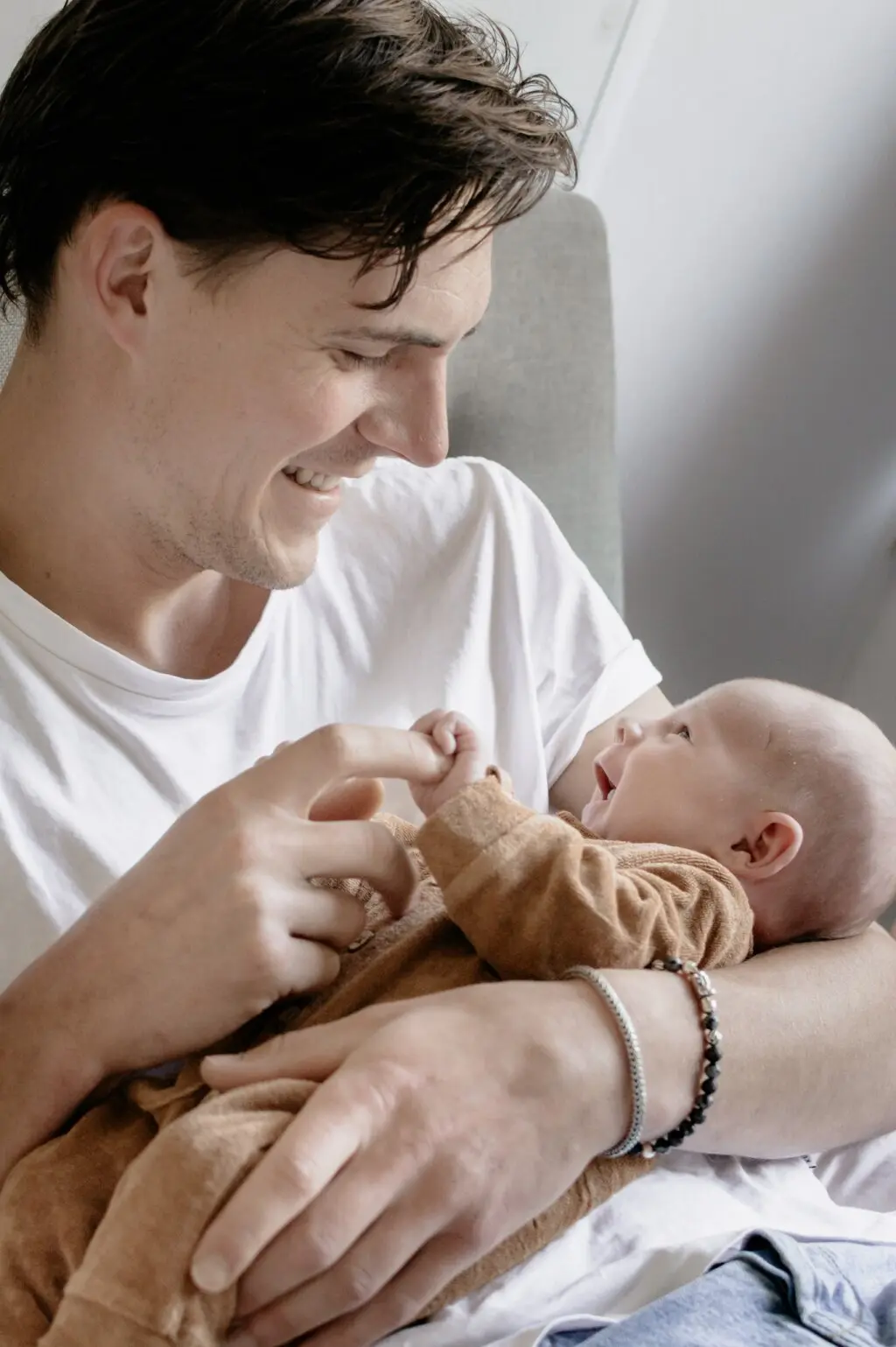 Newbornshoot bij gezin thuis — pasgeboren baby in armen van moeder